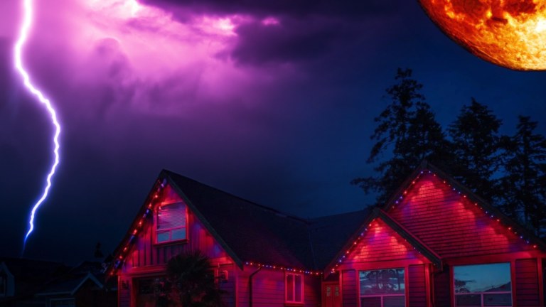 A house is lit up with Gemstone Lights in orange and purple while a halloween scene of a purple sky and a large orange moon sit in the background.