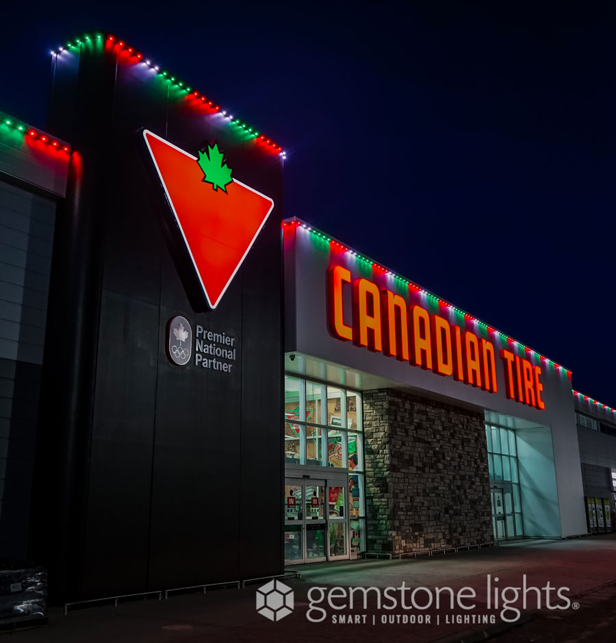 The front of a Canadian Tire retail store with Gemstone Lights in Red, White, and Green in multi-light groups visible above the sign and along the roofline.
