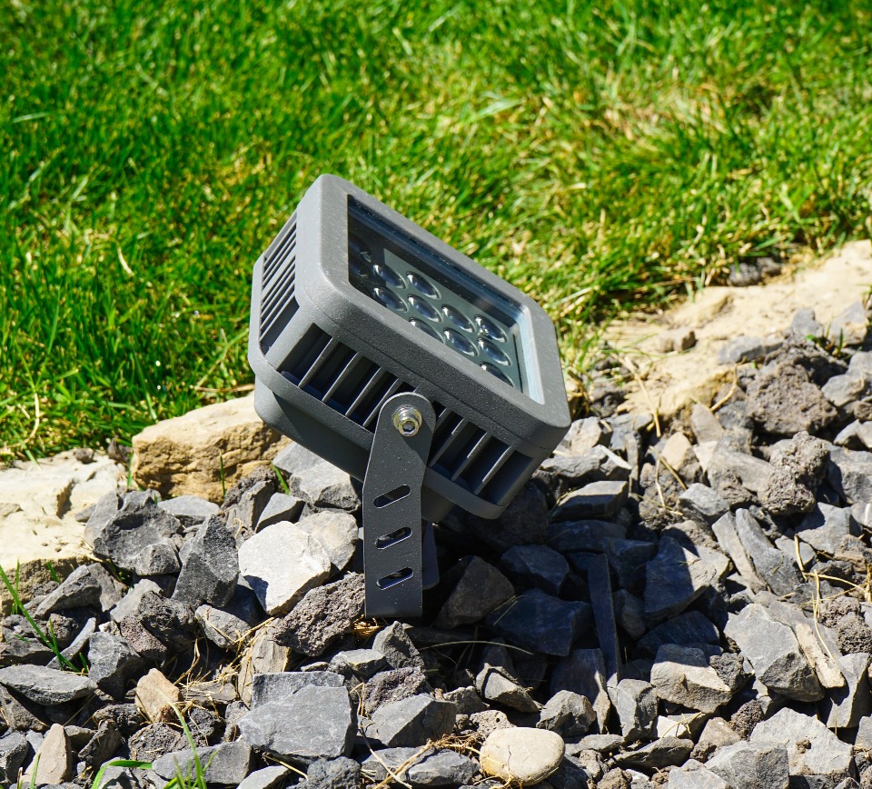 A close up of flood light on a gravel path beside the grass