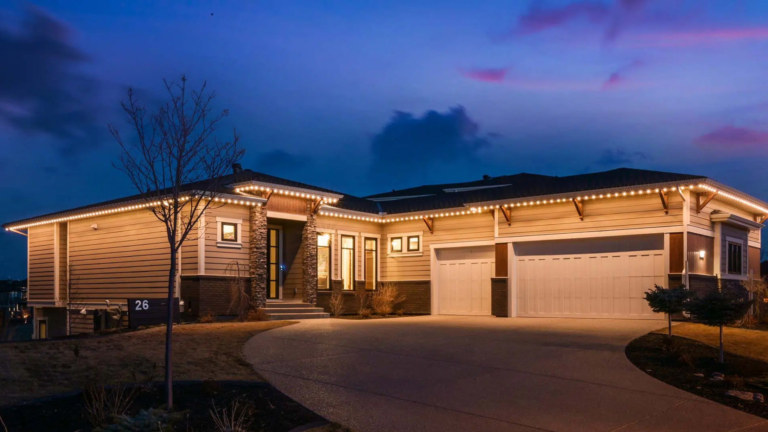 A single story house is lit up for security with Gemstone Lights permanent outdoor lighting.